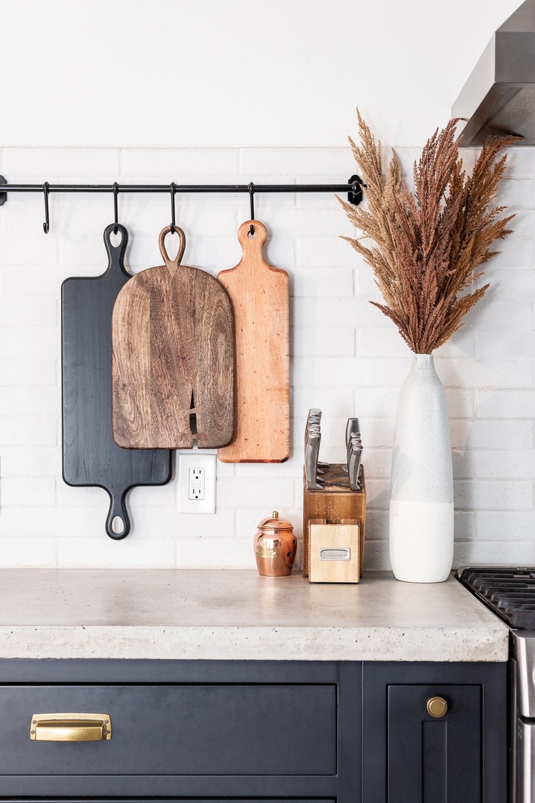 cutting boards hanging from rod in industrial farmhouse kitchen