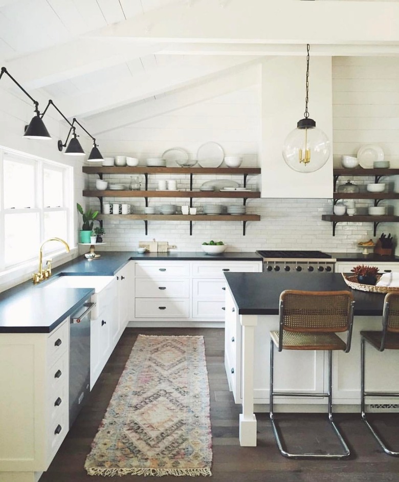 industrial farmhouse kitchen with white cabinets and black countertops