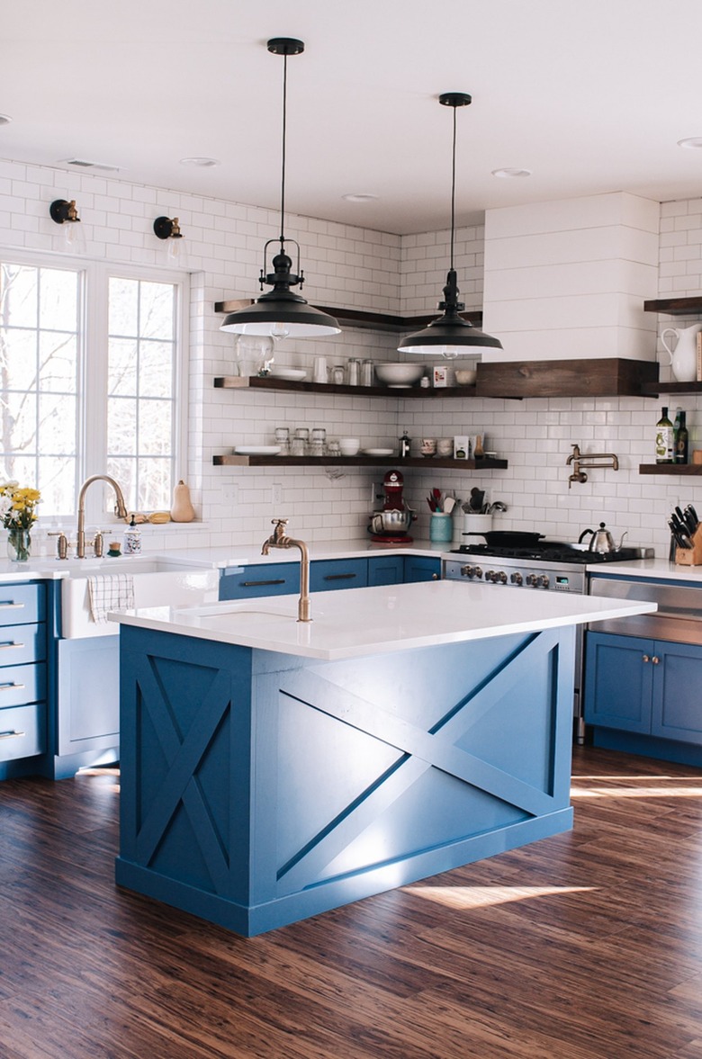 industrial kitchen with blue cabinetry and white backsplash