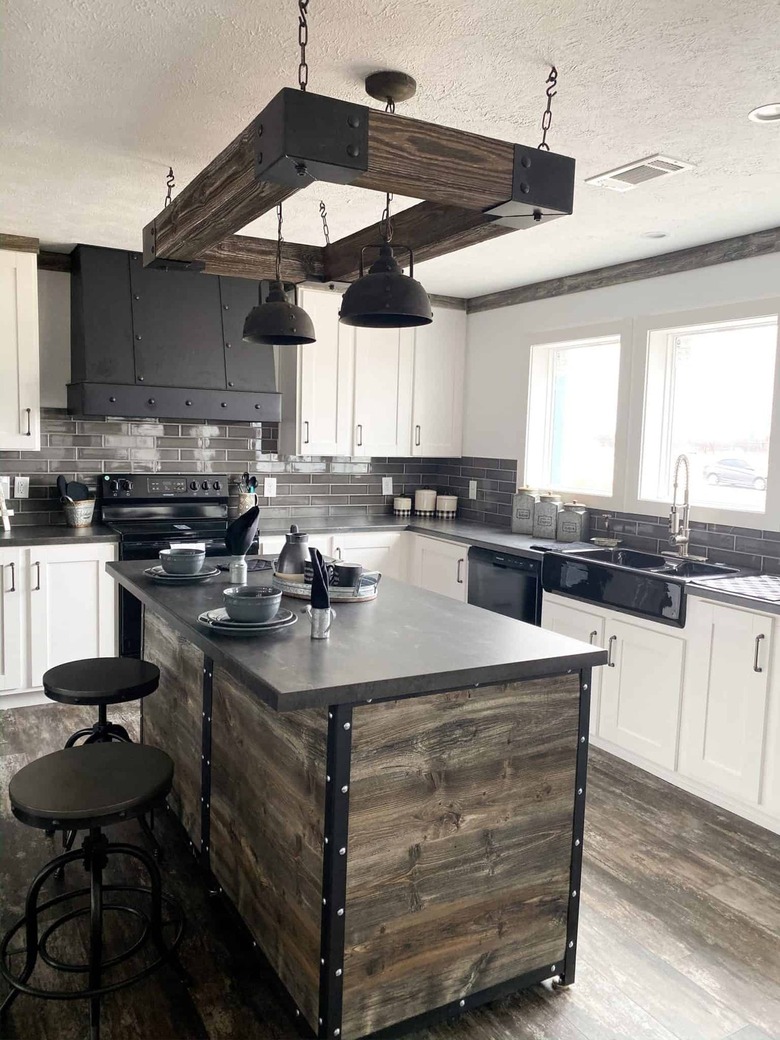 industrial kitchen with wood and black island and hanging lights