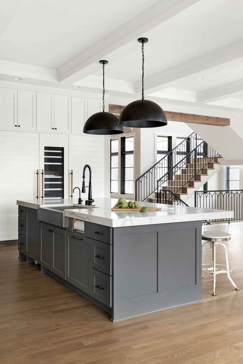 industrial kitchen with gray island and oversized pendants