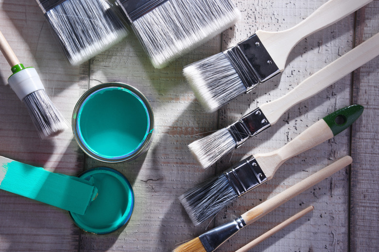 Paintbrushes of different size and paint can