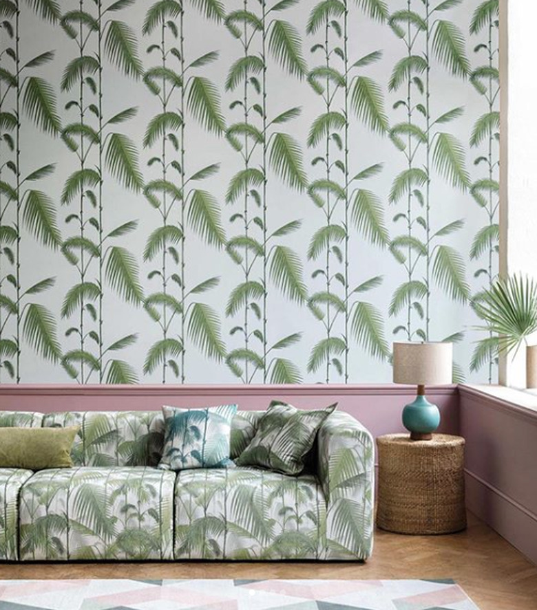 living room wallpaper idea with palm print to match sofa fabric above pink wainscoting