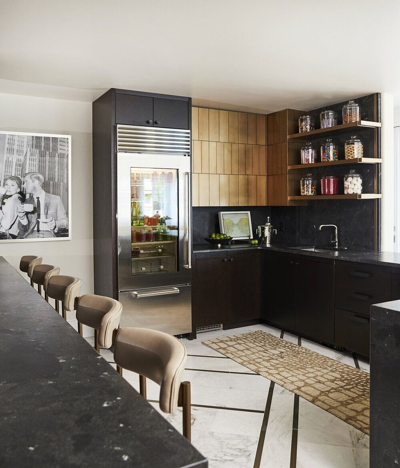 modern black kitchen with open shelving and gold cabinets