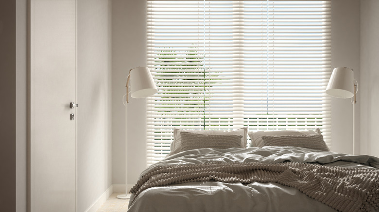 Bedroom in beige tones,  floor lamps, large window with blinds, modern interior design