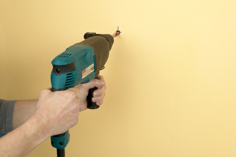 Man using drill to make hole in wall