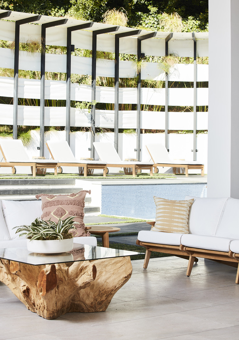 bright outdoor space with white furniture by pool