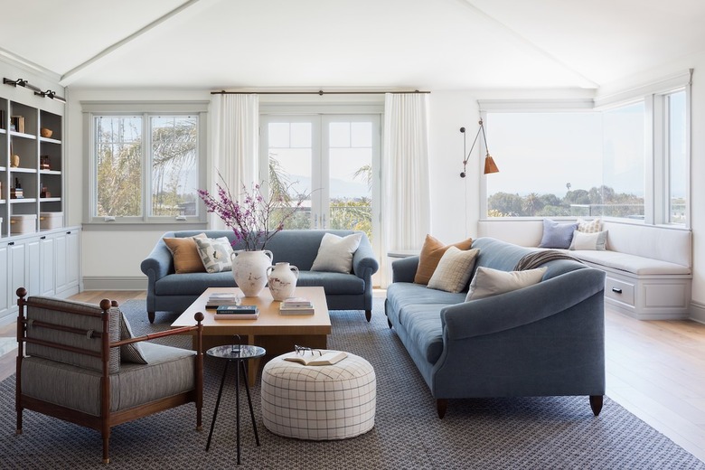 living room with large windows and blue couches