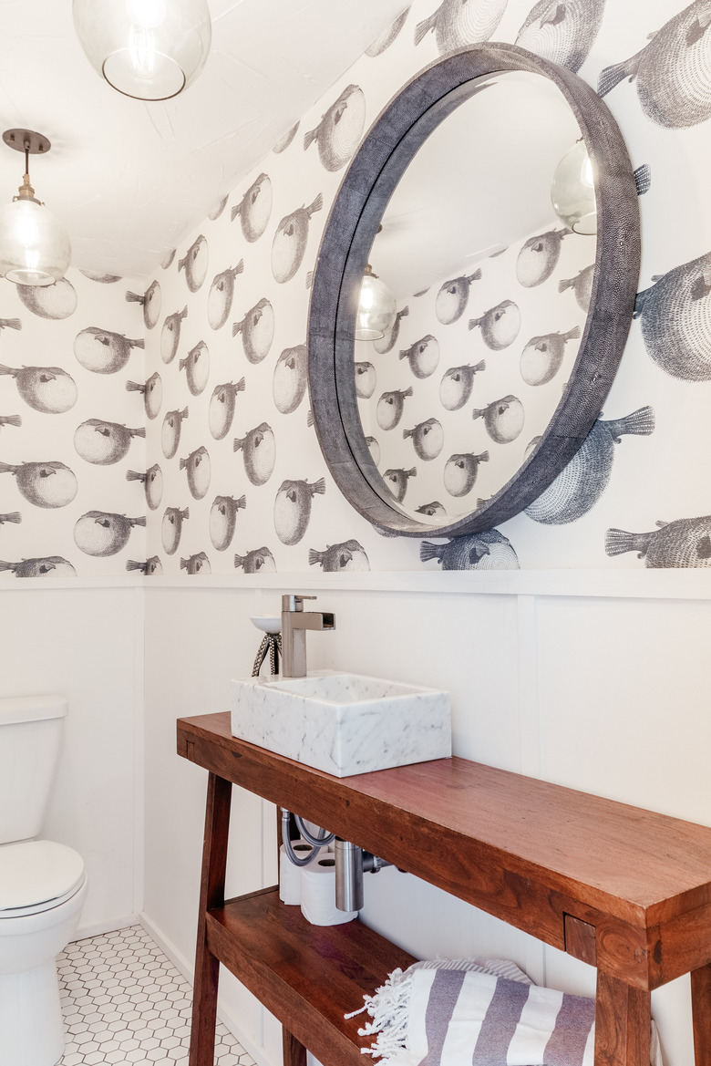 kids bathroom idea with fish wallpaper above white wainscoting and wood vanity