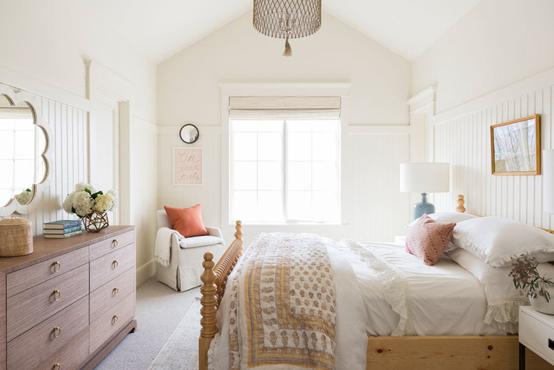 White and airy kids' bedroom idea with wall paneling and mirror above dresser