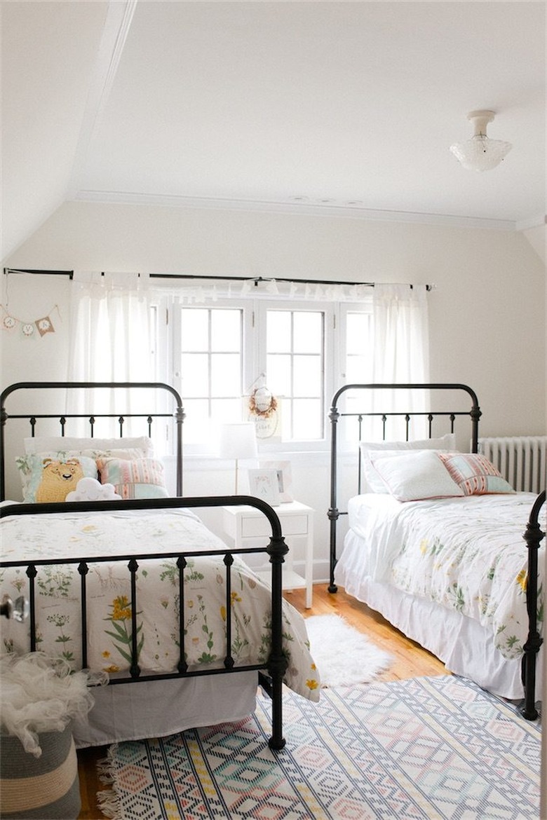 Black and white kids' bedroom idea with metal bed frames and drapery at window