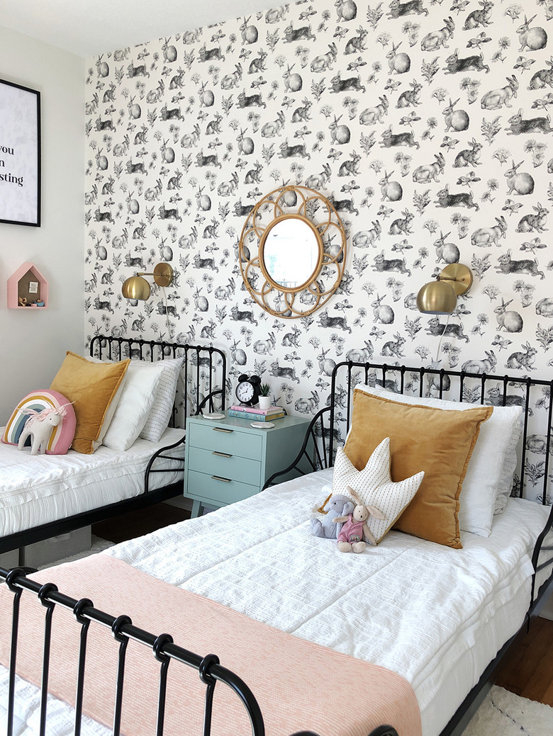 kids' bedroom idea with patterned white wallpaper  and brass fixtures