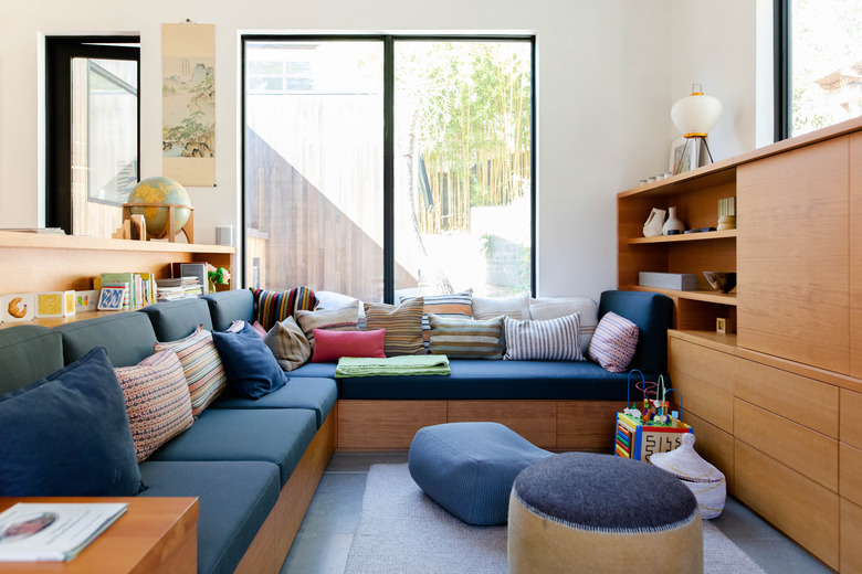 Modern blue kids' playroom idea with wood furniture and throw pillows