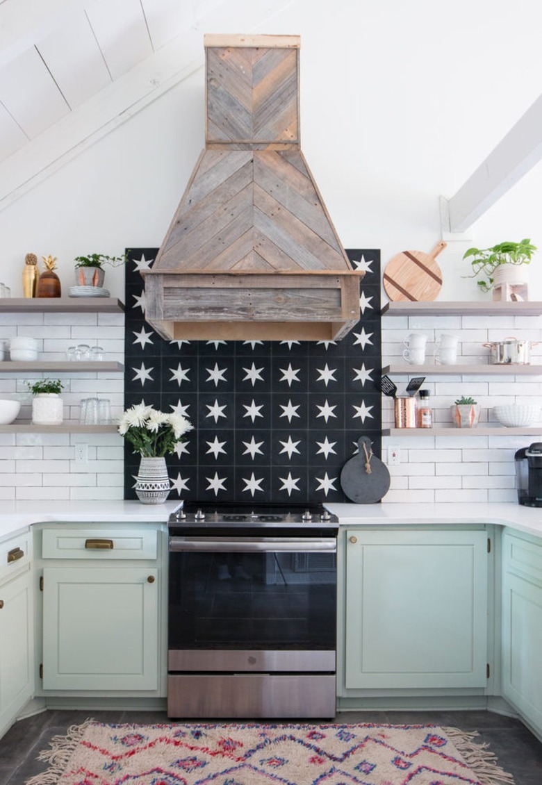 mint green kitchen cabinets with patterned tile backsplash