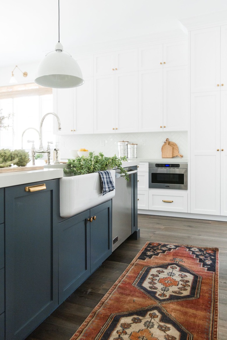 kitchen cabinet style with blue shaker cabinets and farmhouse sink with rug on floor