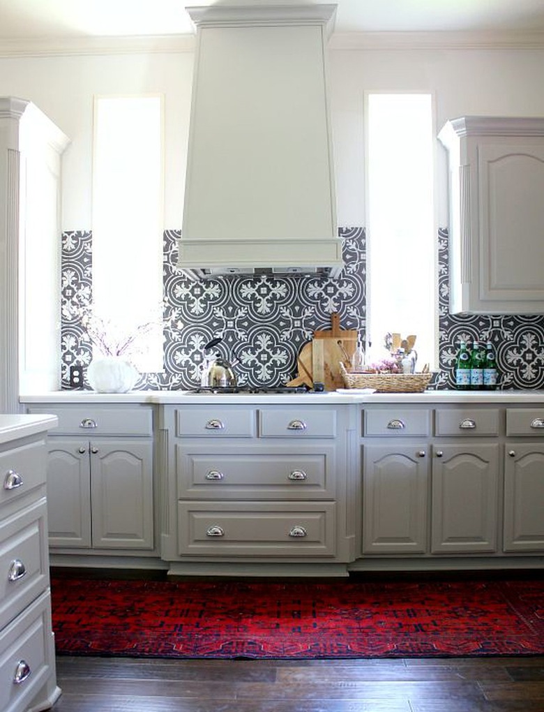 white cathedral cabinets in modern kitchen with black and white patterned backsplash