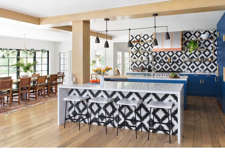 graphic tile kitchen with blue cabinets and slim profile chandelier