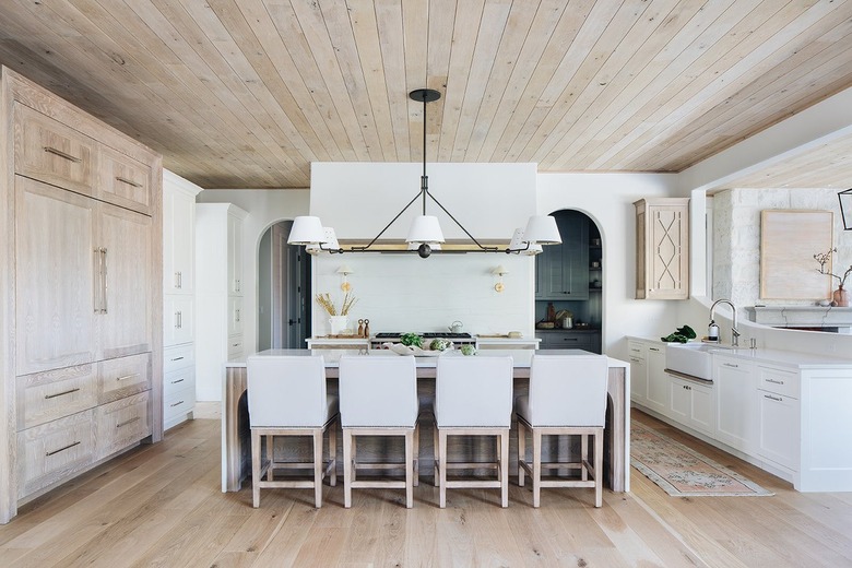 tonal wood forward kitchen with large chandelier over island