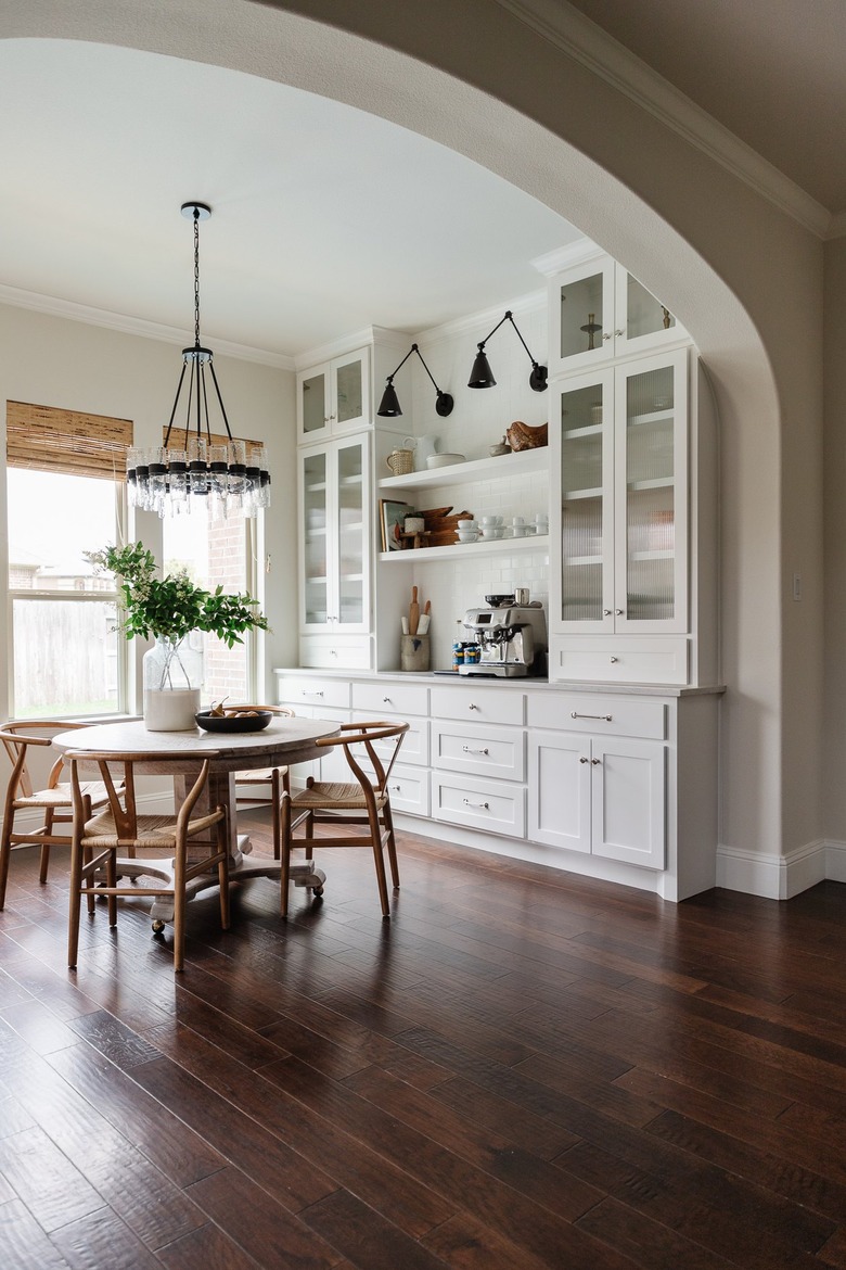 Dining room with built-in coffee bar, wood table and black light fixtures.