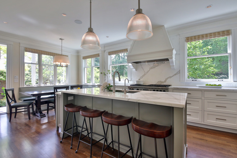 kitchen with white island, hardwood floor, and wooden bar stools