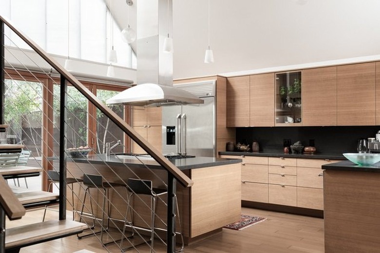 Kitchen with wood cabinets, large island, large stainless hood.