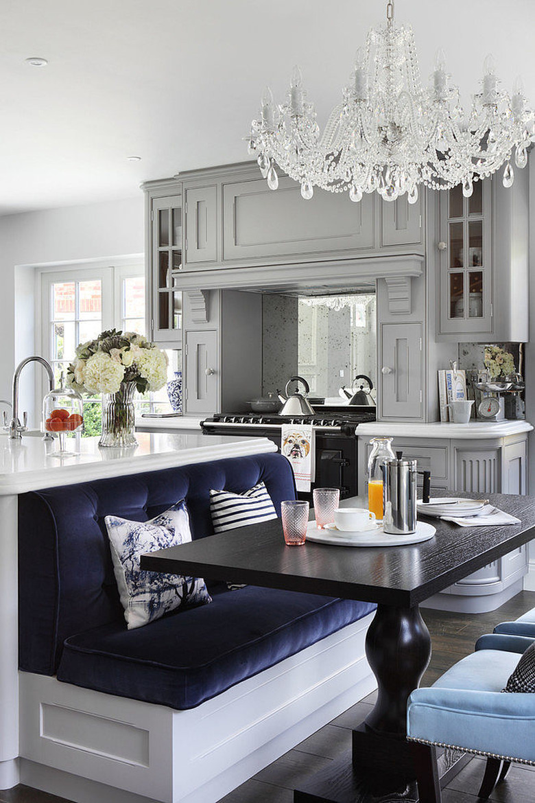 chandelier and navy velvet kitchen island with bench seating