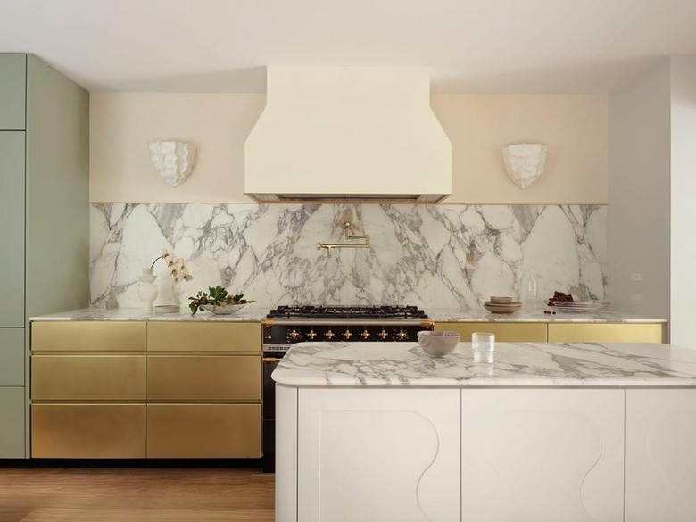 kitchen with marble backsplash and brass cabinet fronts