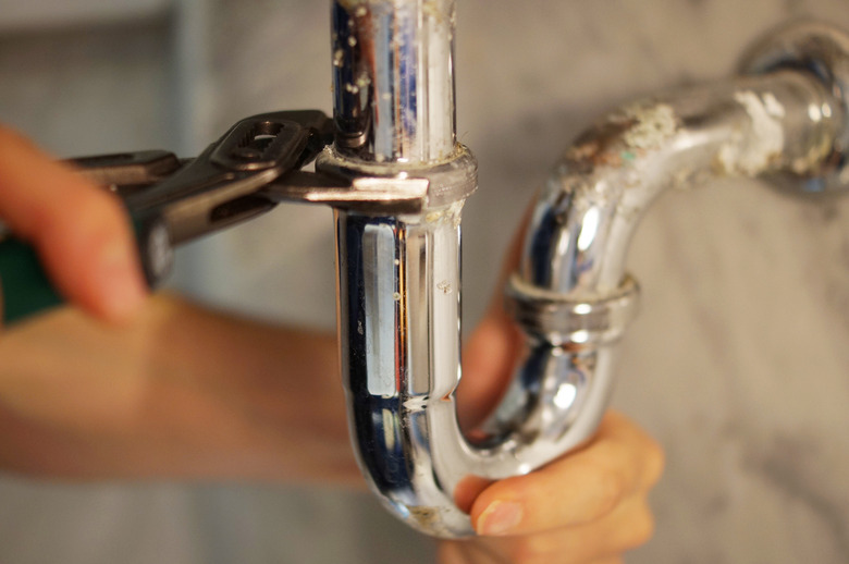 Closeup of plumber fixing pipe with wrench