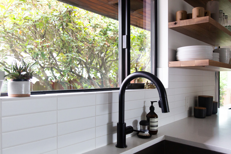 undermount kitchen sink and gooseneck kitchen faucet with white countertops and subway tile backsplash