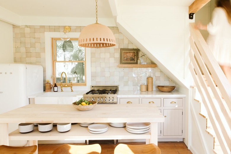 white Smeg refrigerator, pendant lamp and wooden kitchen island with beige tiled backsplash