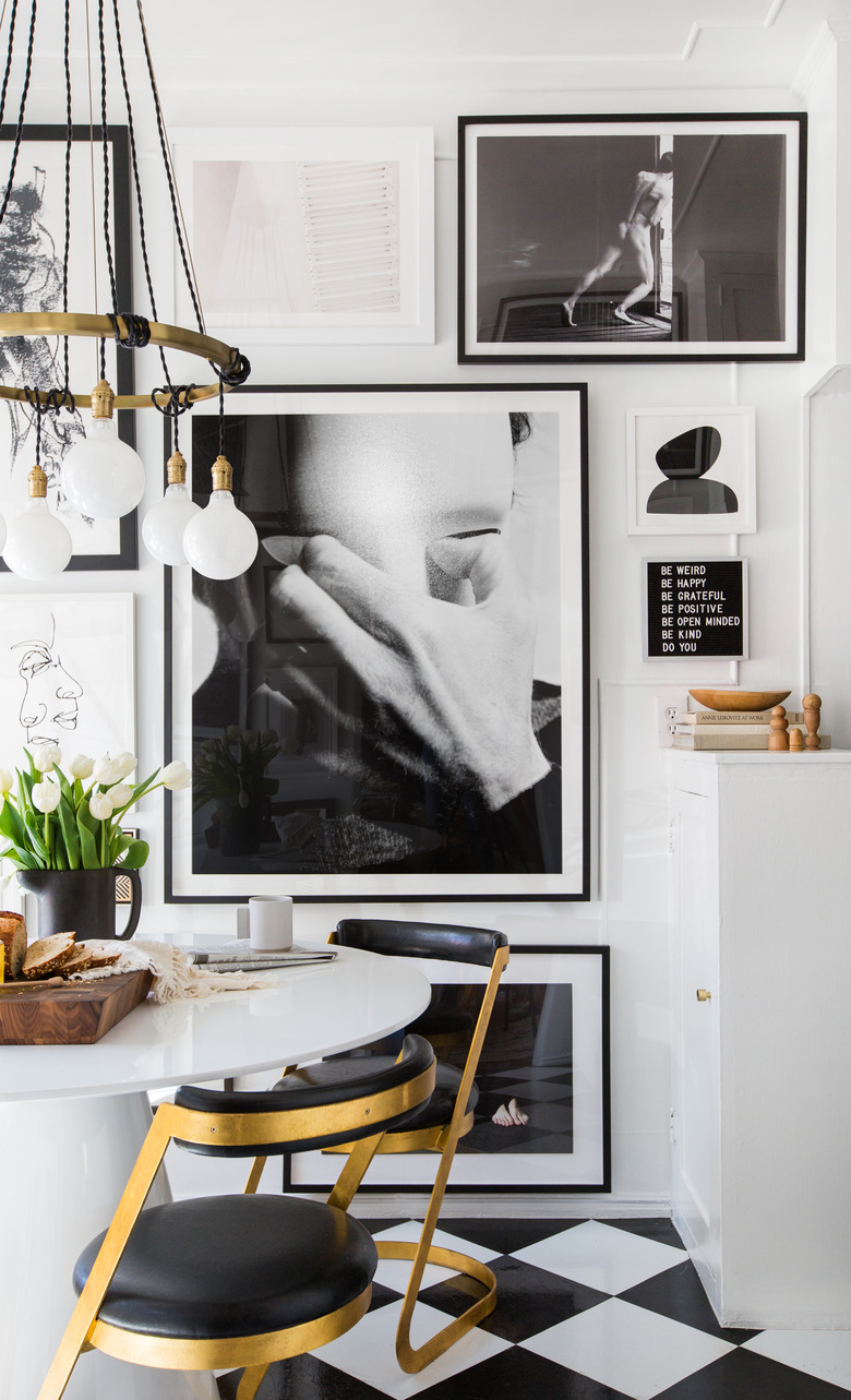 black and white kitchen vinyl flooring with gallery wall and white cabinets