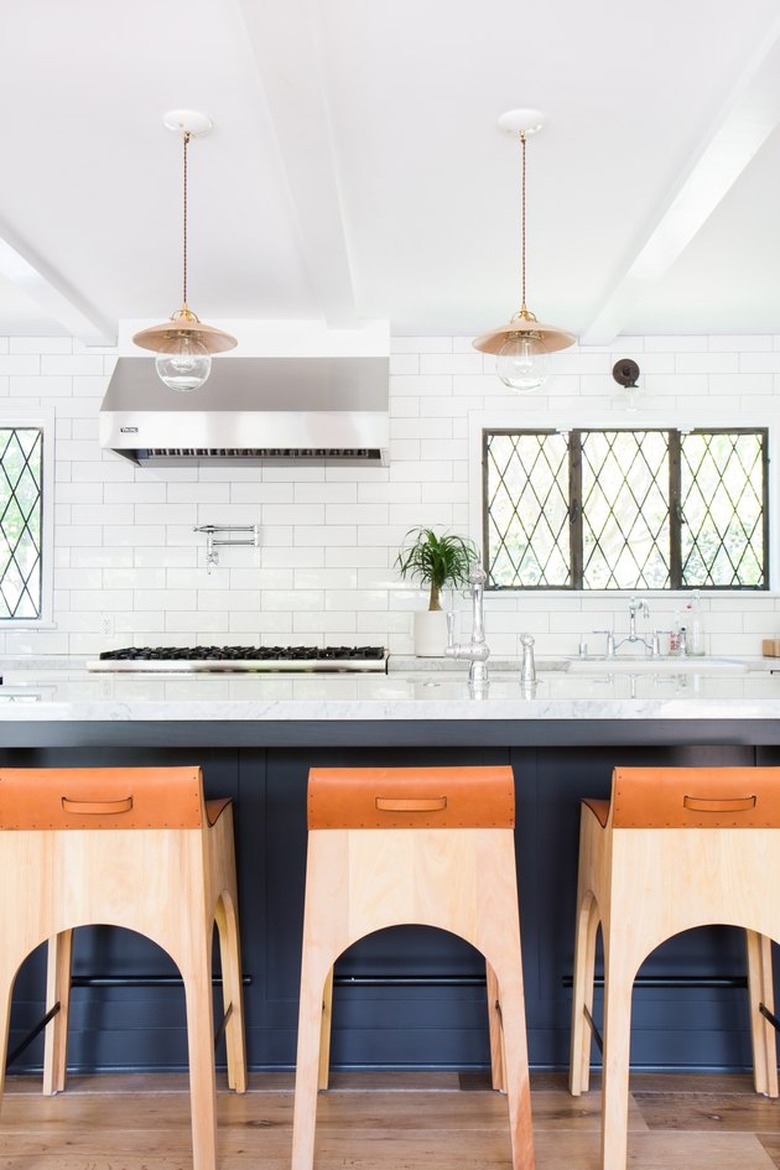 Muntin kitchen window in a vintage-modern kitchen with a blue island and white subway tiles