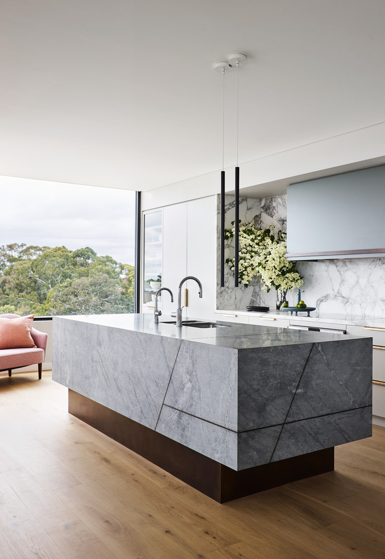 large open kitchen with marble island and blue cabinets