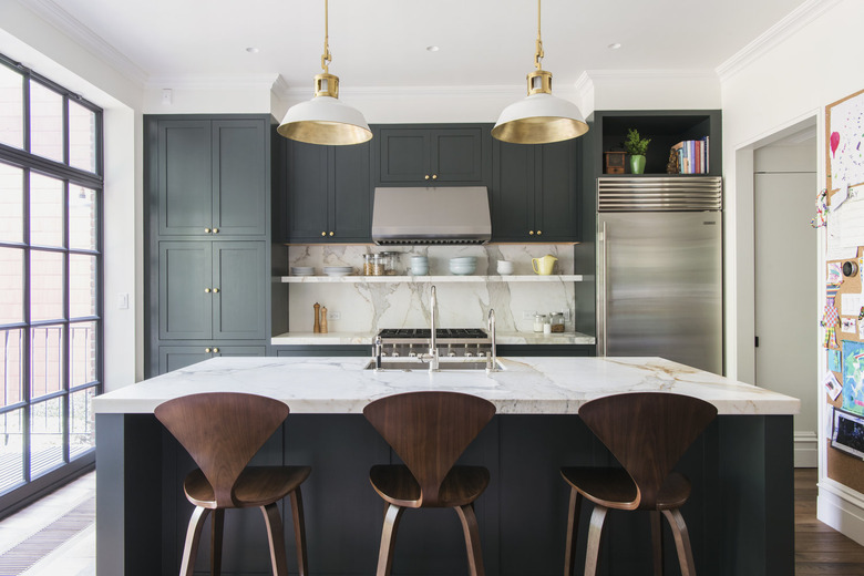 large open kitchen with green cabinets and marble island