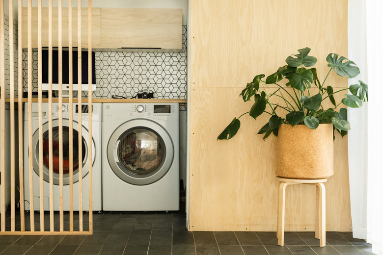 laundry room idea with light wood and patterned backsplash behind appliances