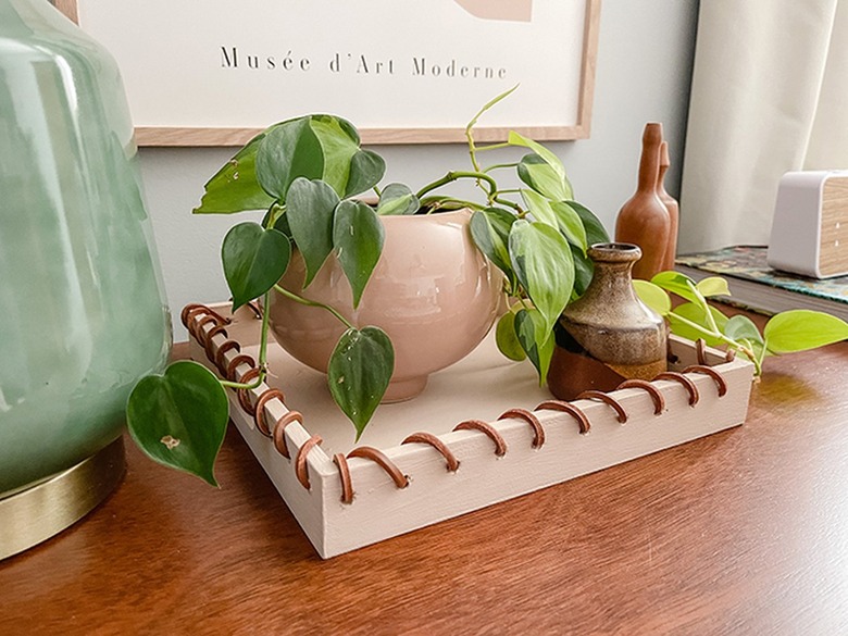 Leather-wrapped tray with plant and vases