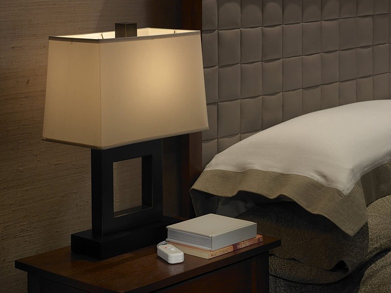 Bedside lamp with dimmer next to modern upholstered headboard