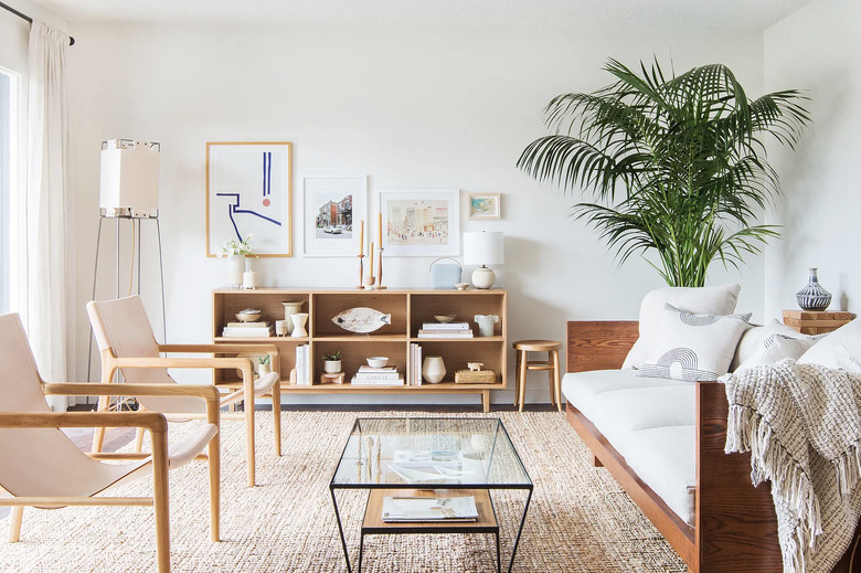 living room rug idea with a neutral living room, white and wood couch and pink and wood chairs over a jute rug with a glass coffee table