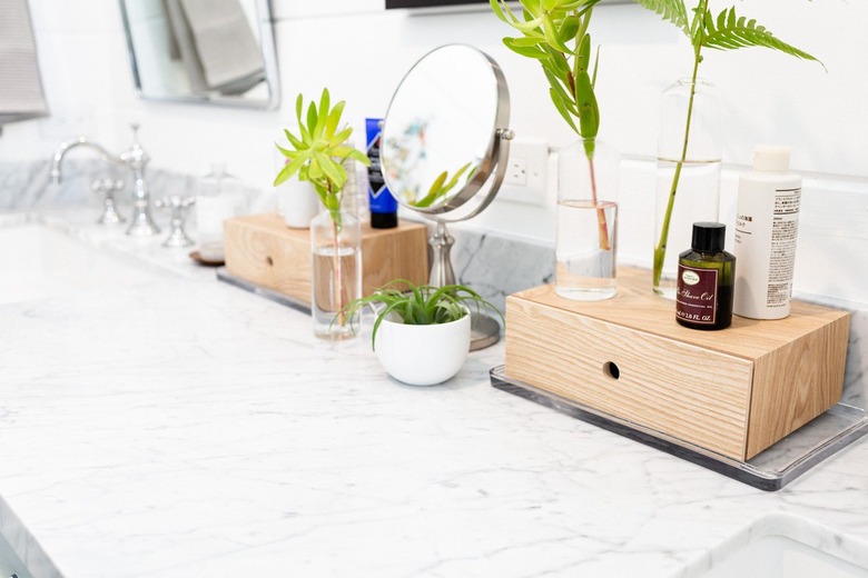 Makeup Organizer Ideas on Bathroom vanity, wood storage container drawers, cosmetics, mirror, plants, sink, mirror.