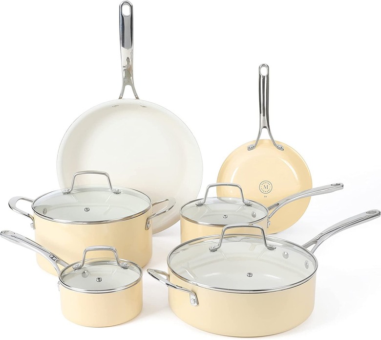 An eight and ten inch frying pan, a 1 quart covered sauce pan, a 2.5 quart covered sauce pan, a 4.6 quart covered sauce pan and a 5.5 quart covered dutch oven, all in the color butter cream are displayed in front of a white background.