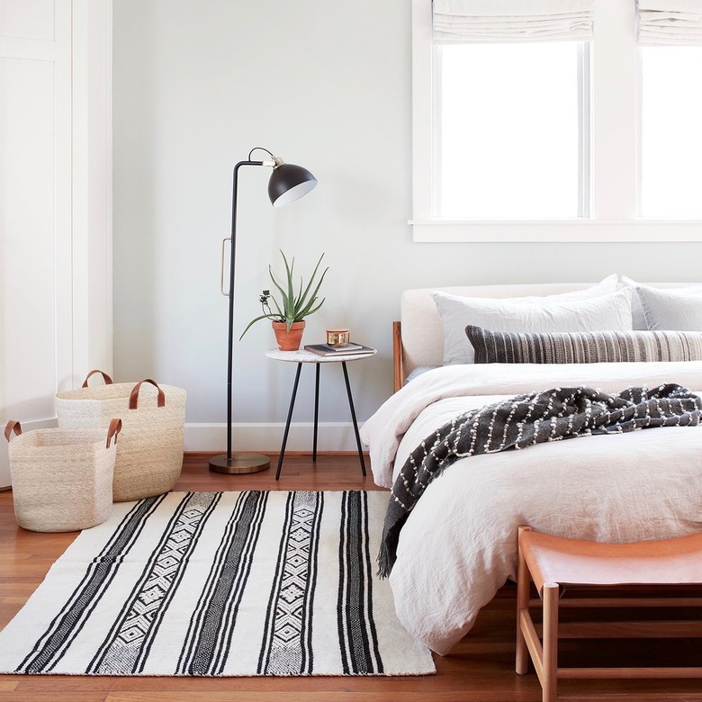 masculine boho bedroom with modern floor lamp and patterned textiles