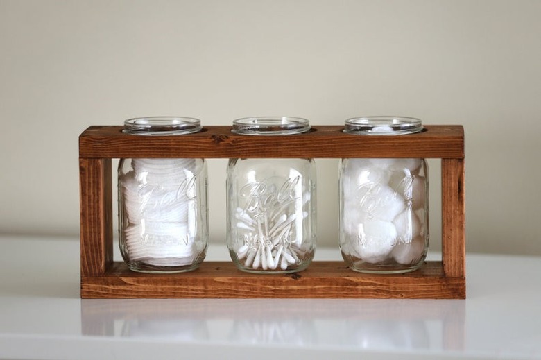 mason jar for bathroom storage in wood caddy with cotton balls and Q-tips