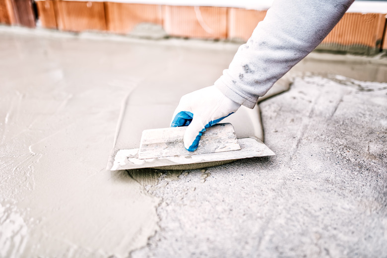 construction worker using trowel and mason's float for waterproofing house