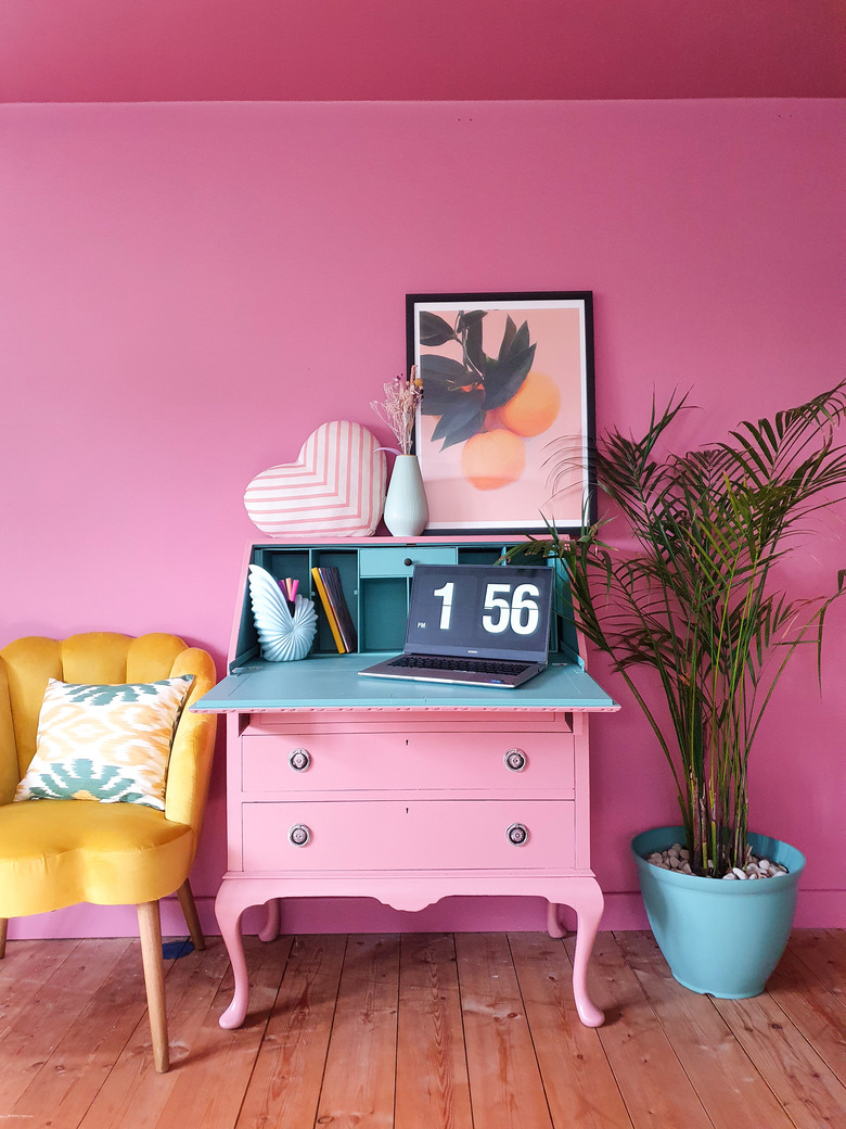 hot pink maximalist home office with pink secretary desk and yellow accent chair