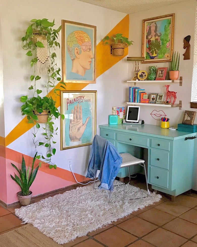 maximalist home office with colorblock walls and blue desk, wall art