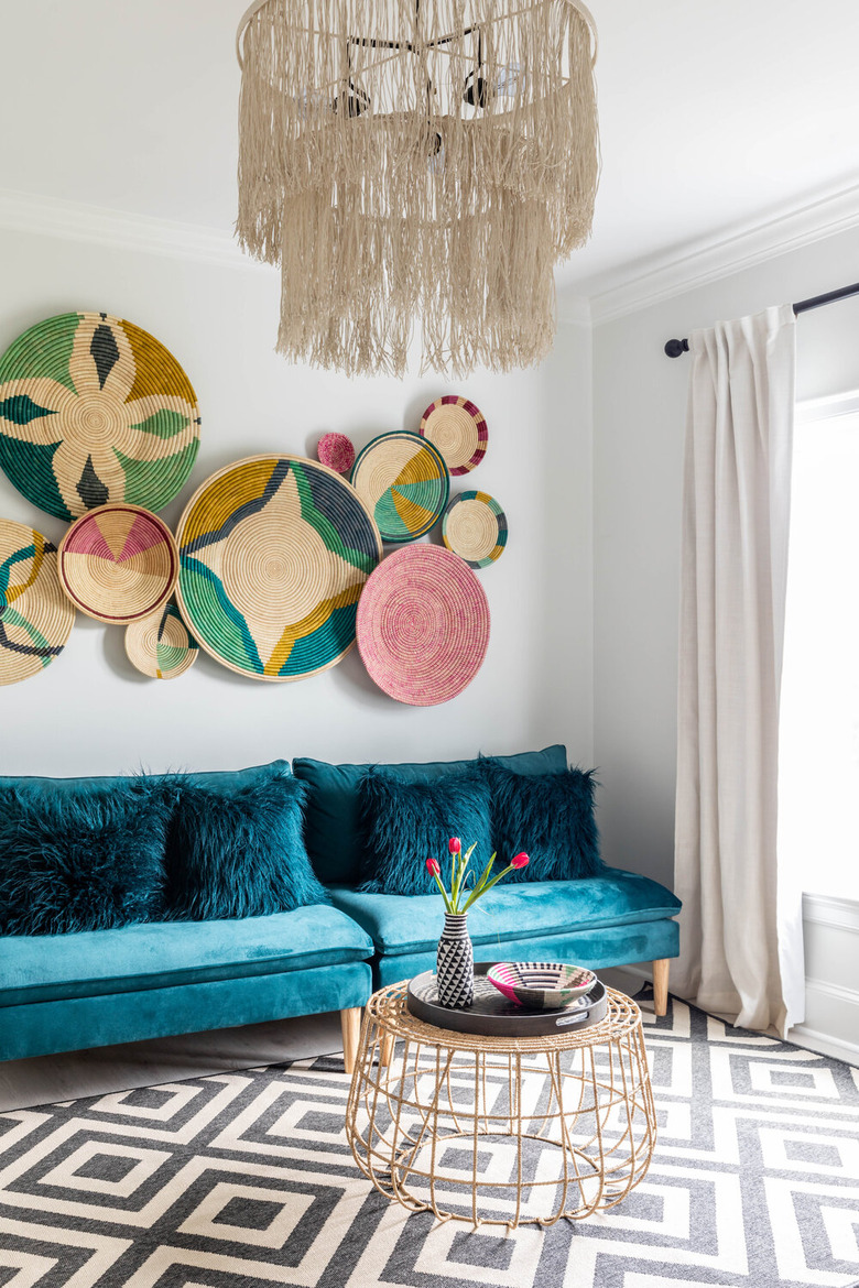 maximalist living room with blue sofa and basket wall hangings