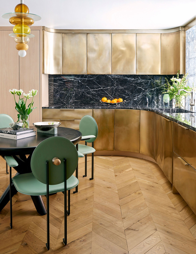 kitchen with brass kitchen cabinets and mint green dining chairs