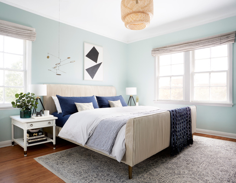 midcentury bedroom lighting idea with woven pendant above bed