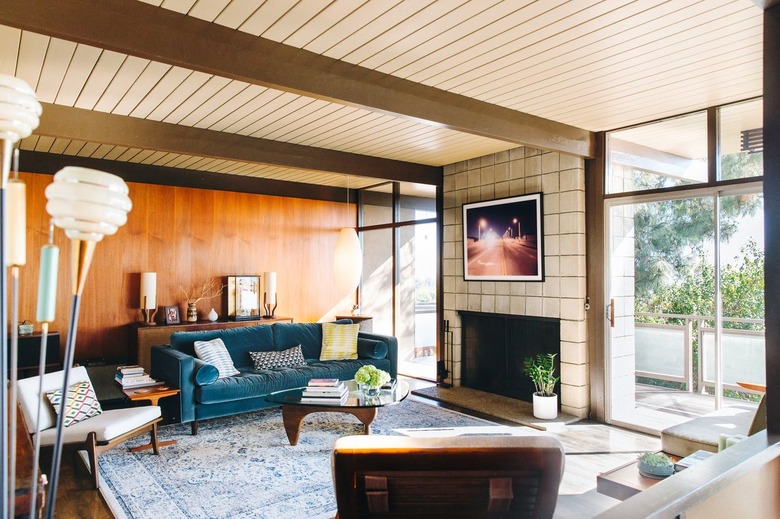 Midcentury living room with paneled walls and large white cinder block fireplace