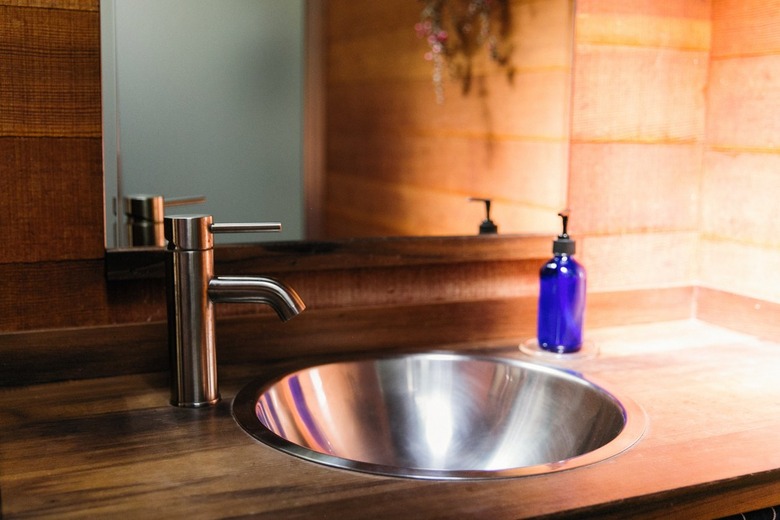 Midcentury Modern Bathroom Sink and paneled walls, round metal sink, faucet, mirror.